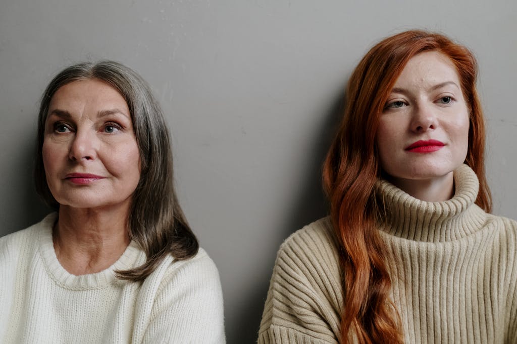A captivating portrait of two women with contrasting hair colors. Warm and thoughtful expressions.